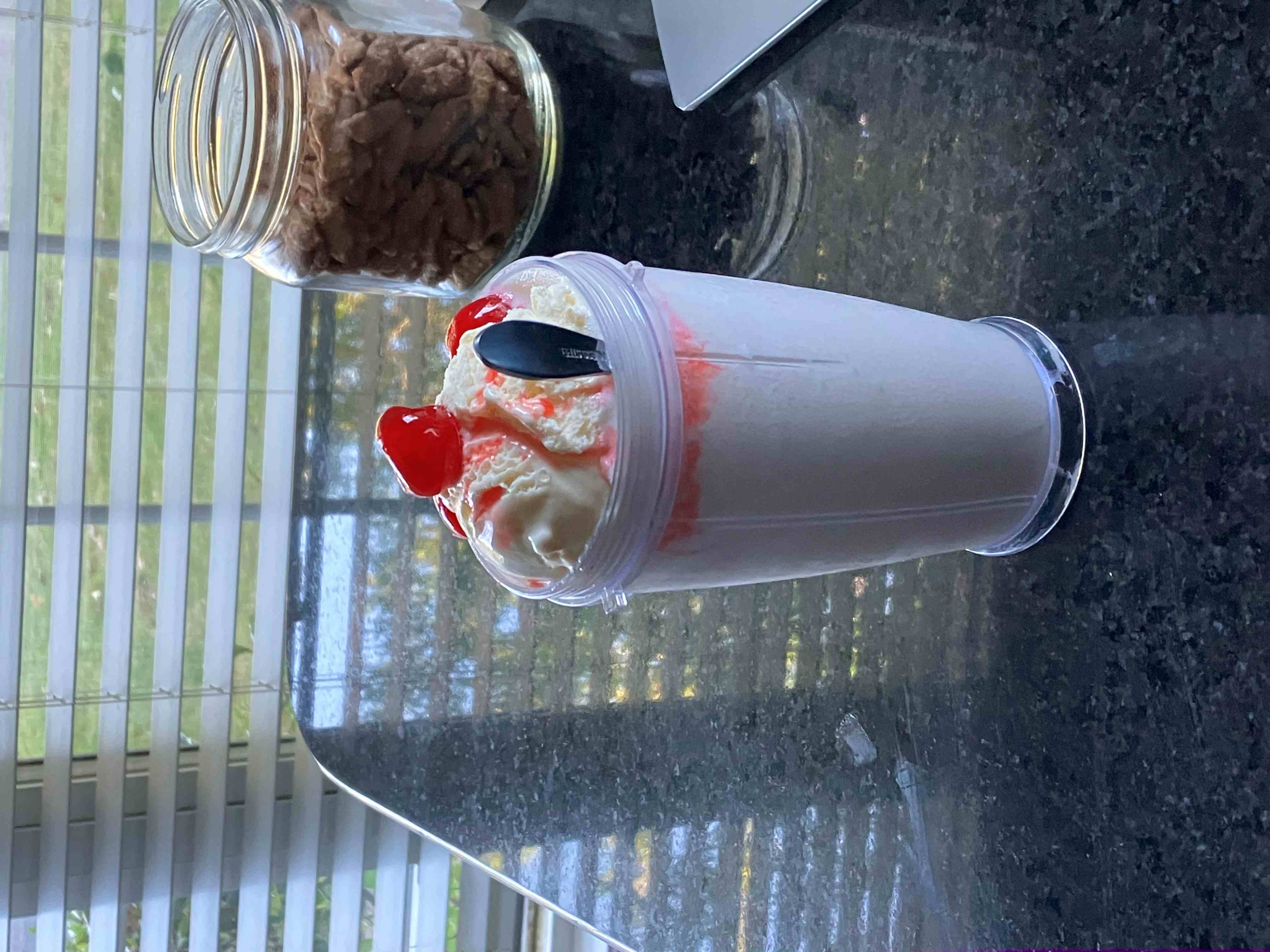 A vanilla milkshake with 2 cherrie