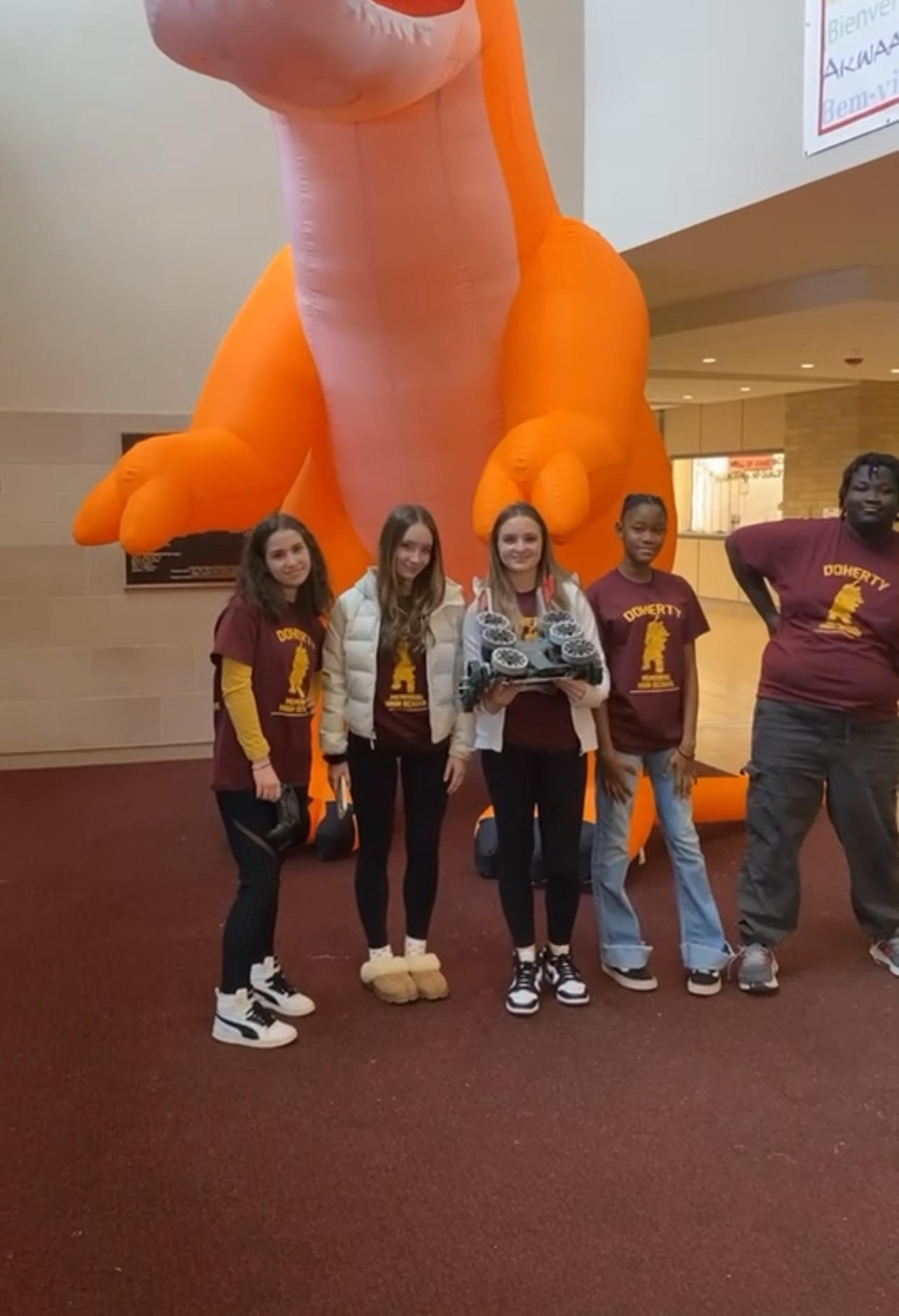  5 people posing with a small robot