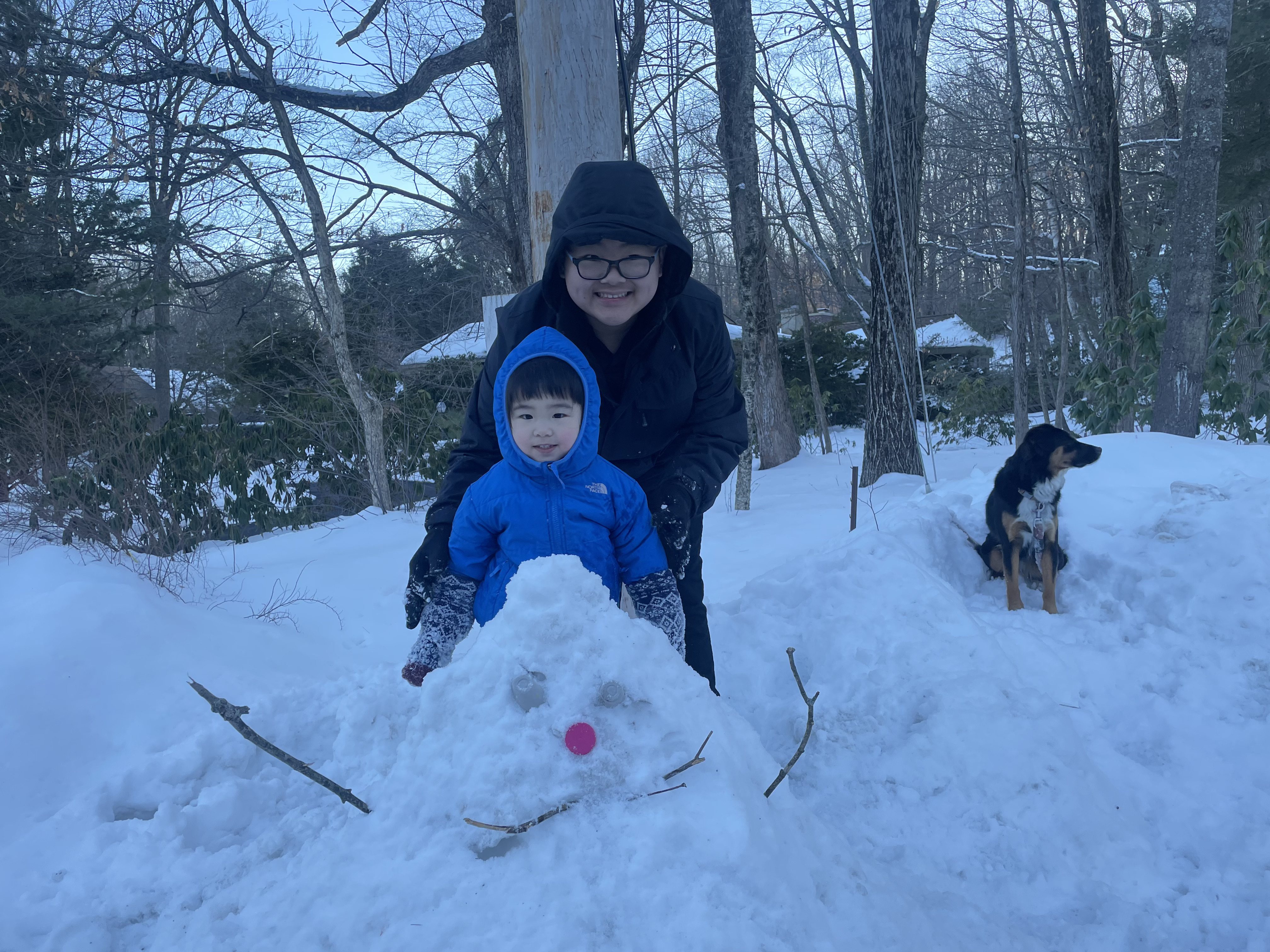 My sister and I taking a photo of our pile-snowman with P2 in the background