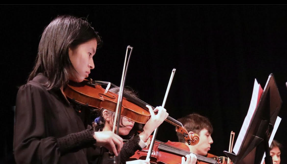 Me in all-black concert dress, playing violin.