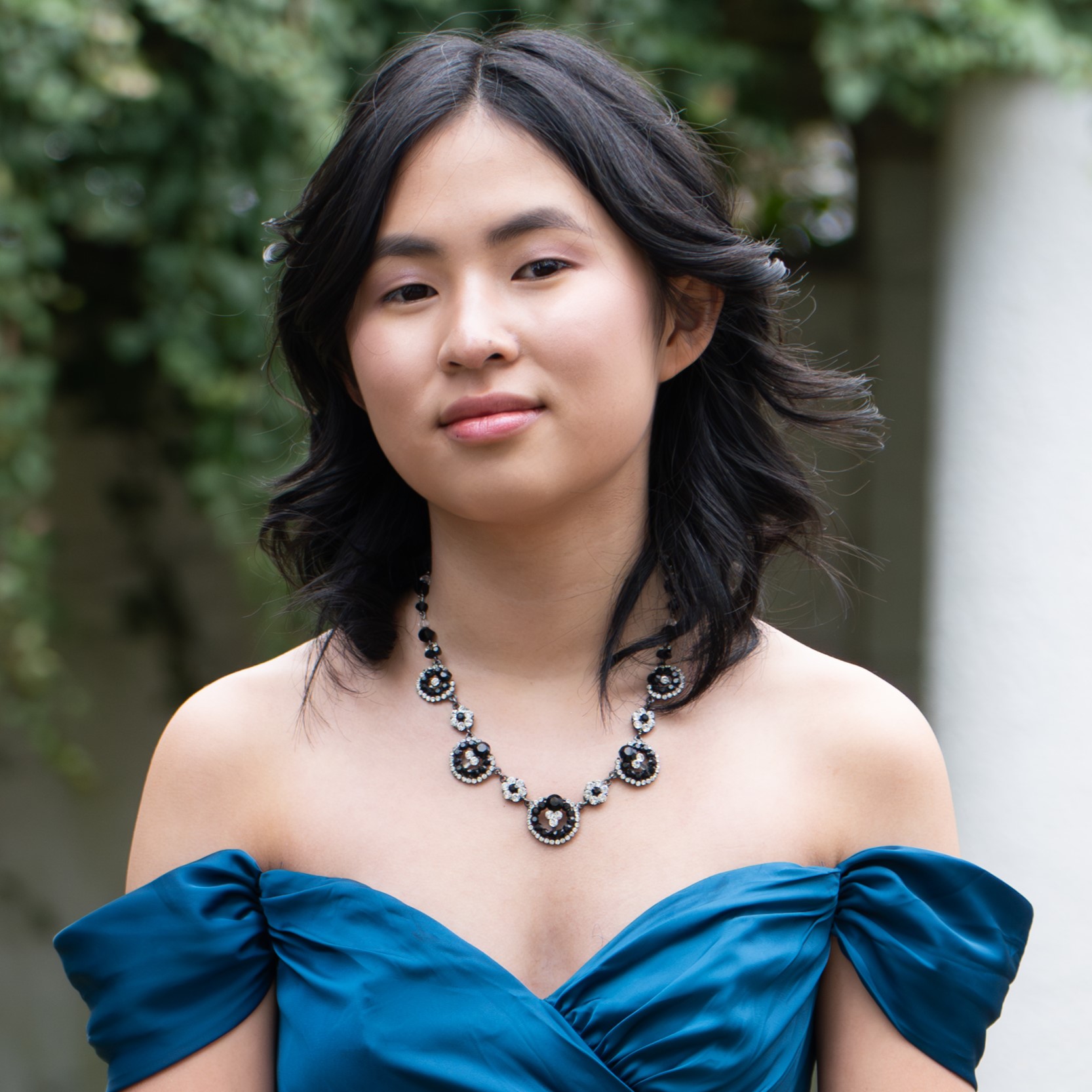 Me in a blue dress and white shawl with my friends at prom last year.