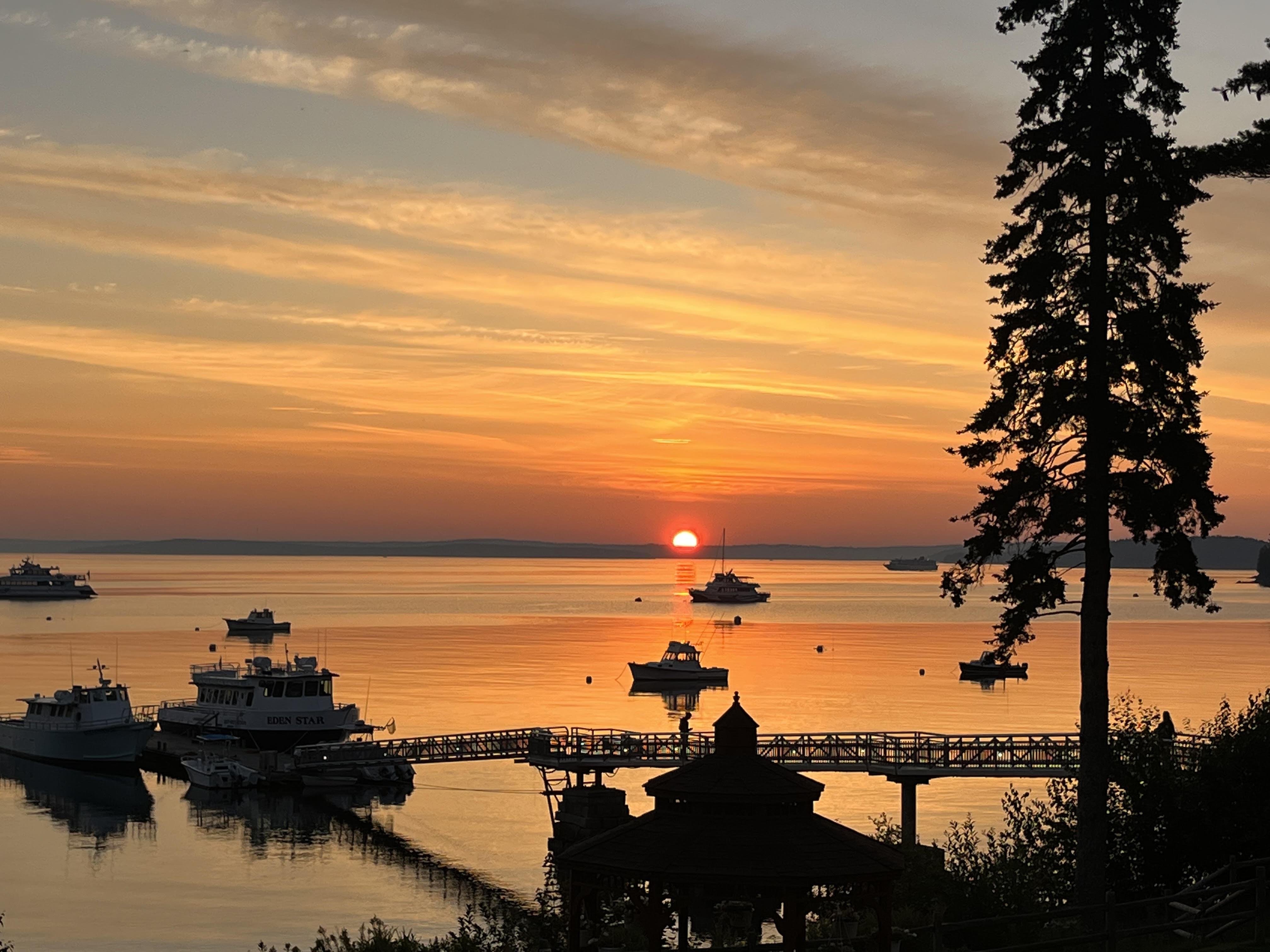 Early sunrise over a bay, with red skies and clouds.