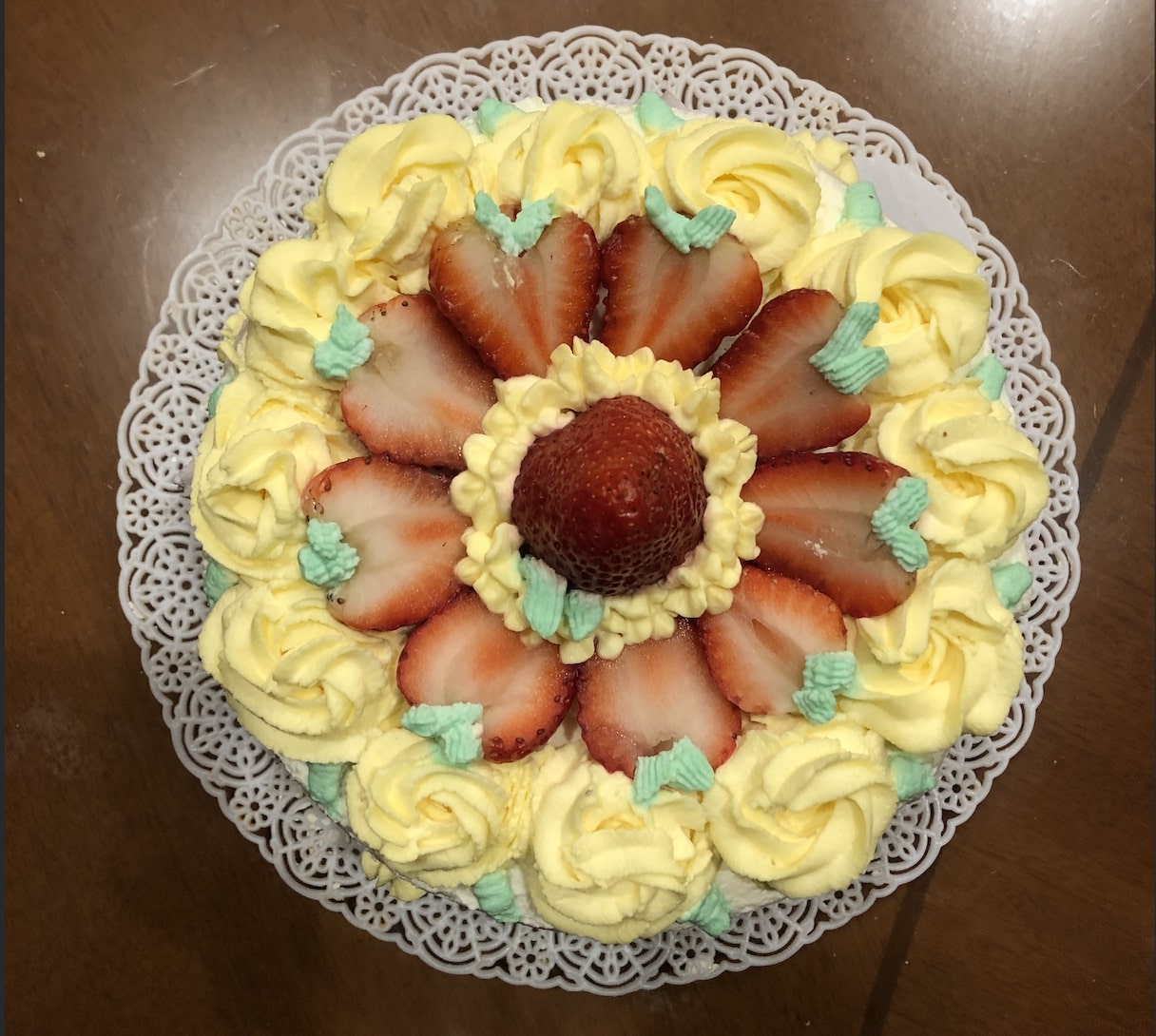 Yellow flower frosted birthday cake with strawberries