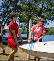 A photo of me and my coworker putting the sailboats into the water