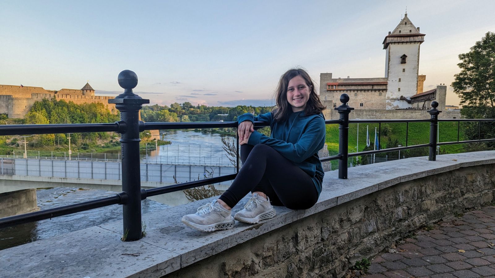 Image of me sitting down with the Russian and Narva Castle in the background.