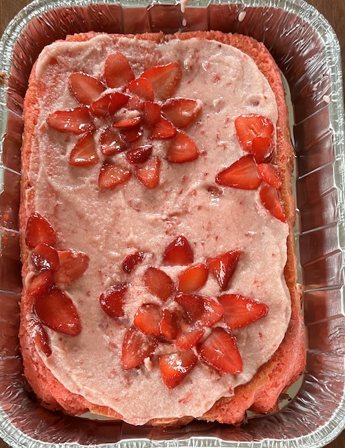 =Sheet cake with pink frosting and flowers made by strawberries