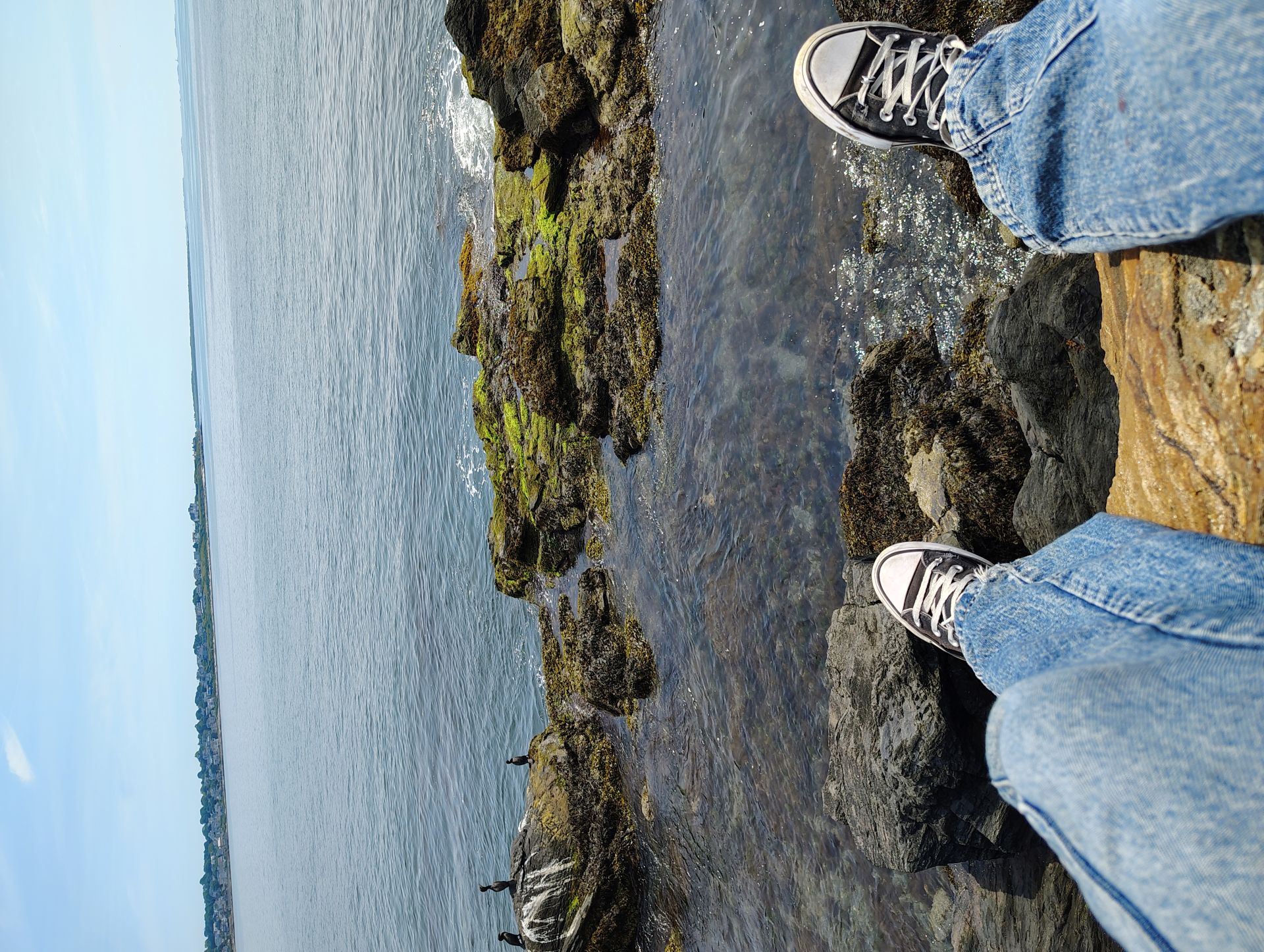 Sitting on a rock some way off trail by the sea in Newport, RI