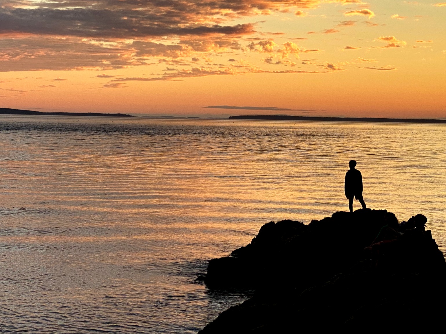 A person standing
            	on a rock in front of the Atlantic Ocean.