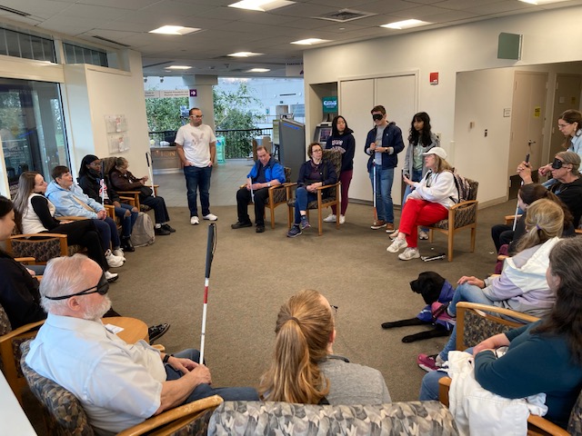 A photo of me talking with both sighted guides and VIPs, visually impaired person