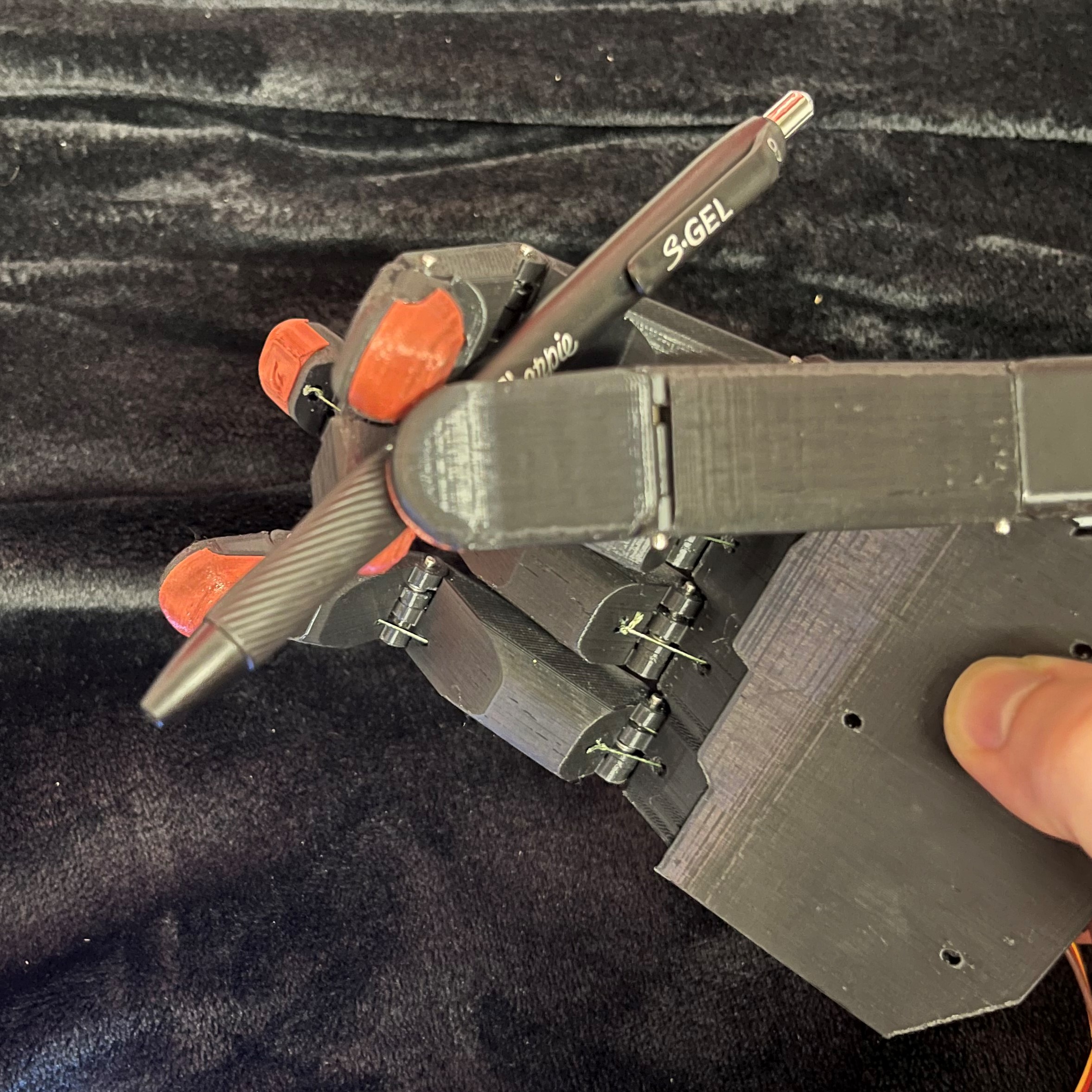 The hand is holding a pen with the middle finger, index finger, and thumb.